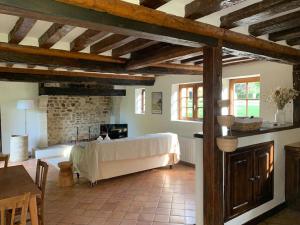 a bedroom with a bed in a room with wooden beams at La Cidrerie du Haras in Léaupartie +12 photos