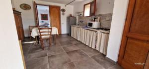a kitchen with a table and a kitchen with a table and chairs at Mursia Casa Vacanze in Pantelleria