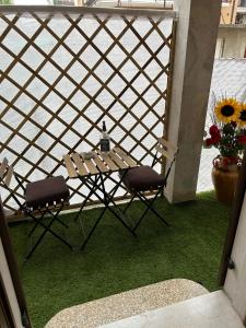einen Tisch und zwei Stühle auf einer Terrasse mit Gras in der Unterkunft Civico 56 in Verona