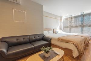 sala de estar con cama y sofá en 谷町君・星Hotel・道頓福居 en Osaka