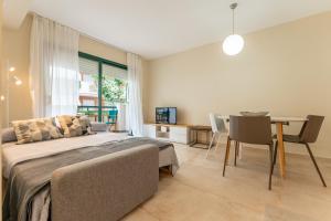 a bedroom with a bed and a table and a dining room at Port Cambrils in Cambrils