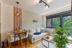 un salon avec un canapé et une table dans l'établissement Rustic Vibe Apartman Zlatibor, à Palisat