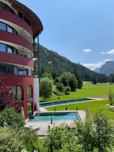 un hotel con piscina al lado de un edificio en Romantik Hotel Santer, en Dobbiaco