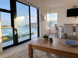 a living room with a table and a view of the ocean at Struisbaai Apartments in Struisbaai