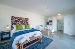 a bedroom with a large bed with green pillows at Struisbaai Apartments in Struisbaai