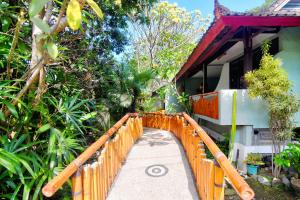 uma ponte de madeira sobre uma passagem em frente a uma casa em Bamboo Paradise em Padangbai