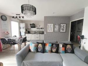 a living room with a couch with pillows on it at Appartement 4 pièces - La Rose des Yvelines - Classé 3 étoiles in Trappes