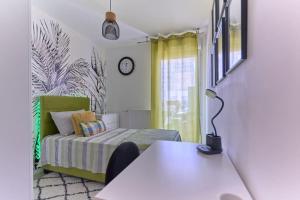 Zimmer mit einem Bett und einem Tisch mit einer Lampe in der Unterkunft Appartement 4 pièces - La Rose des Yvelines - Classé 3 étoiles in Trappes