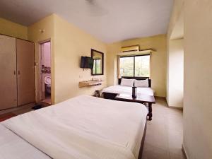 a bedroom with a bed and a desk in it at Hotel Blue Valley in Mount Ābu