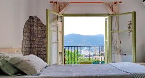 a bedroom with a bed and a window with a view at Marchie's Place - Spacious one bedroom apartment for rent on Skopelos Island in Skopelos Town