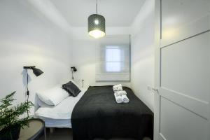 1 dormitorio pequeño con 1 cama con manta negra en Vibrant 2BR apt w Balcony 5-min from the Beach by Sea N' Rent, en Tel Aviv