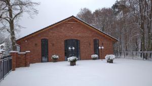 a red brick building with snow in front of it at Red Barn in Spała