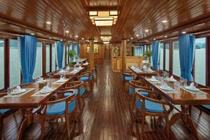 a dining car of a train with tables and chairs at Cozy Bay Cruise in Ha Long