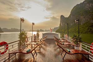a dock with benches on a boat in the water at Cozy Bay Cruise in Ha Long