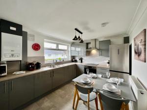 a kitchen with a table and chairs and a refrigerator at Havenwood House - Serene Escape Cottage in Nottingham