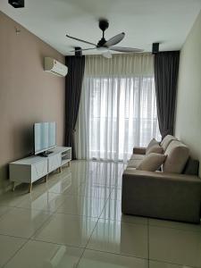 a living room with a couch and a television at Metropol Suite in Bukit Mertajam