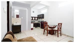 - une cuisine et une salle à manger avec une table et des chaises dans l'établissement Noel Apartments, à Cochin
