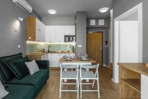 sala de estar con sofá verde y cocina en Apartamenty KAPRYS - Centrum en Krynica Zdrój