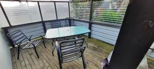 balcón con mesa y sillas en la terraza en Anchors Away (the boaties paradise) en Whanganui