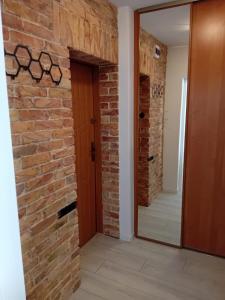 pasillo con pared de ladrillo y puerta de madera en Noclegi u Marylki, en Gniezno