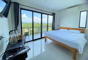 a bedroom with a bed and a large window at De Saran Lanta in Ko Lanta