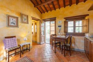 cocina con mesa y sillas en una habitación en Borgo Dolci Colline Resort Querce, en Castiglion Fiorentino