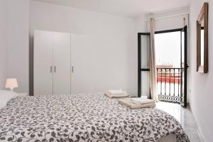 een slaapkamer met een bed en een groot raam bij Exclusive Malaga Apartments with Cathedral Views and Auto Check-in in Málaga