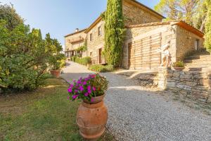 una casa con una maceta al lado de una carretera en Borgo Dolci Colline Resort Querce, en Castiglion Fiorentino