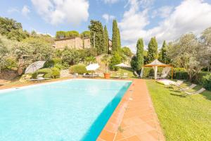 una imagen de una piscina en un patio en Borgo Dolci Colline Resort Querce, en Castiglion Fiorentino
