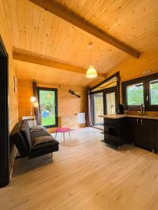 un grand salon avec un canapé et un piano dans l'établissement chalet nature sur la vallée de la Truyère, à Neuvéglise