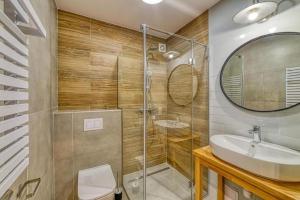 a bathroom with a shower and a sink and a mirror at Natura Mierzei 30 in Krynica Morska