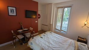 1 dormitorio con cama, mesa y ventana en "Maison verte" - terrasse - parking - 10min du métro en Montreuil