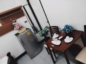 Habitación pequeña con mesa y nevera pequeña. en Baan Rao Boutique Residence, en Chiang Mai