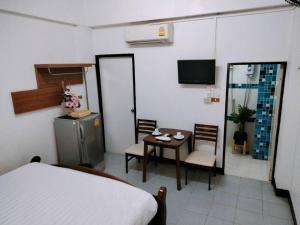 Habitación con cama, mesa y sillas. en Baan Rao Boutique Residence, en Chiang Mai