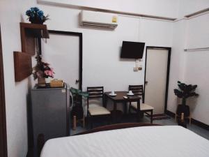 Habitación con cama, mesa y sillas. en Baan Rao Boutique Residence en Chiang Mai