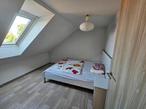 um pequeno quarto com uma cama e uma janela em Velký dům s krásnou zahradou em Kobylí