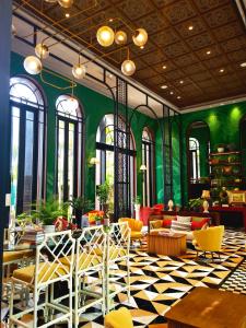 a lobby with yellow and green walls and tables and chairs at LAHABANA Resort in Hua Hin