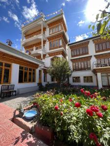 a building with a flower garden in front of it at New Moon Guest House in Leh