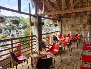Zimmer mit roten Stühlen und Tischen auf dem Balkon in der Unterkunft Winnie's Lodge in Shillong