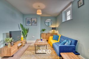 a living room with a blue couch and a tv at Homely and Cosy 3-bed Home in Lincoln by Renzo, Amazing Location, Close to Cathedral and Castle! in Lincolnshire