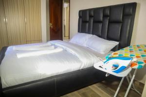 een groot zwart bed met een babybedje ernaast bij Cosy Flamingo furnished apartments in Nakuru