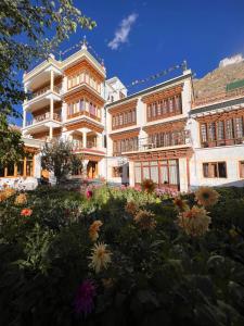 a large building with flowers in front of it at New Moon Guest House in Leh