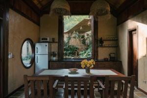 a kitchen with a table and a refrigerator at Lily’s Home & Retreat - Venue Travel in Tien Xuan