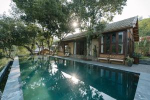 a swimming pool in front of a house at Lily’s Home & Retreat - Venue Travel in Tien Xuan