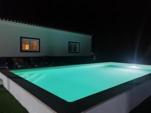 a swimming pool at night with blue lighting at Monte do Rochinha in Monte da Cardosa