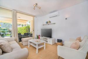 ein Wohnzimmer mit weißen Möbeln und einem TV in der Unterkunft Villa Pyp in Port d'Alcúdia