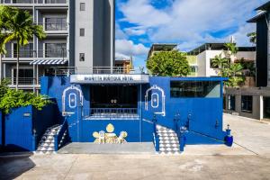 a blue building with two chairs in front of it at Bhukitta Boutique Hotel Phuket Town in Phuket