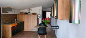 a kitchen with wooden cabinets and a table with pink flowers at Moderne Vintage Ferienwohnung in Bad Schussenried