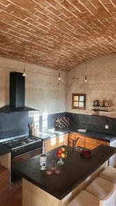 ベルゴデールにあるVilla de Charme "L'Ombria" cadre exceptionnelのキッチン(黒いカウンタートップ、コンロ付)