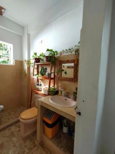een badkamer met een wastafel, een toilet en een spiegel bij Sea Me in Kansaloay